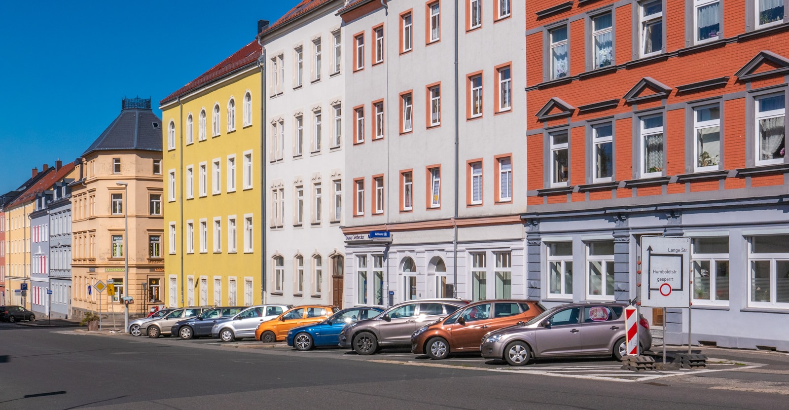 assorted-color cars parked beside apartments with renters insurance